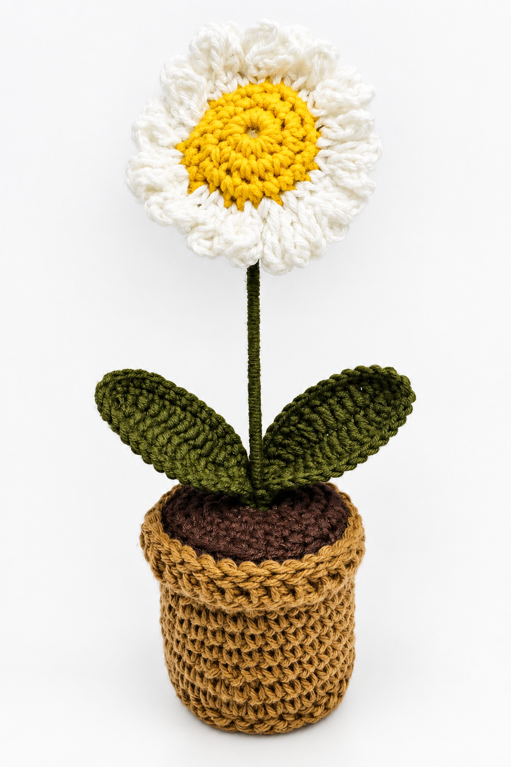 White crochet daisy with a yellow centre and green leaves in the Ivory Daisy Pot.