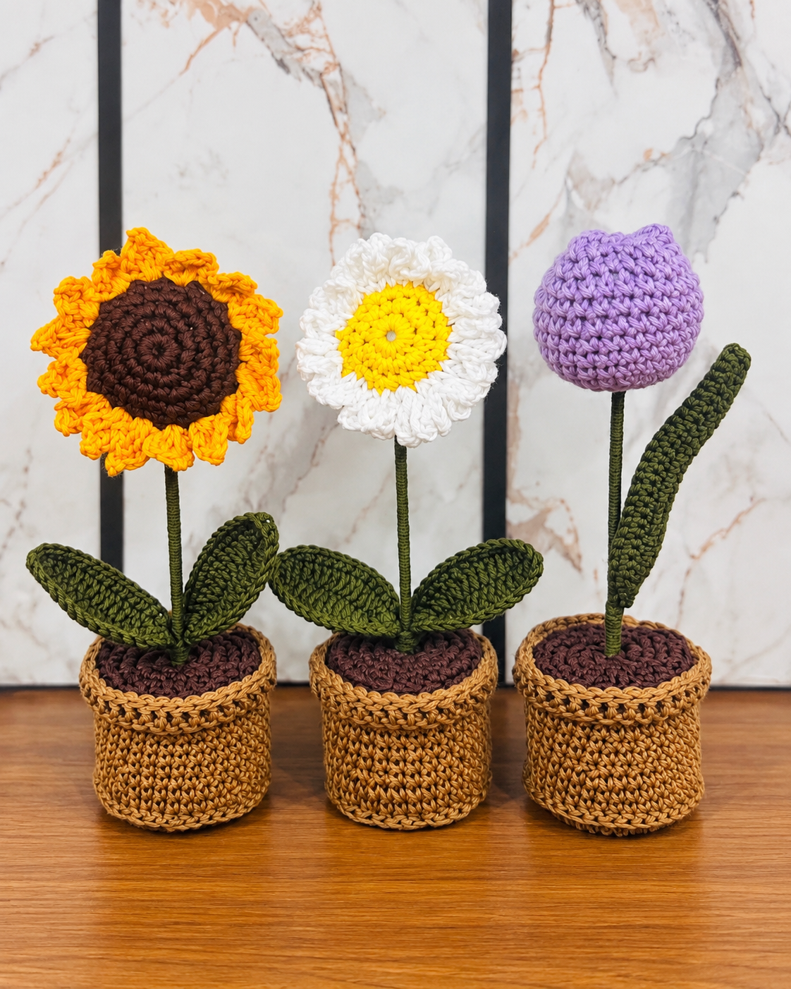 Bloom Trio Garden Collection lined up on a wooden tabletop against a marble-patterned wall.