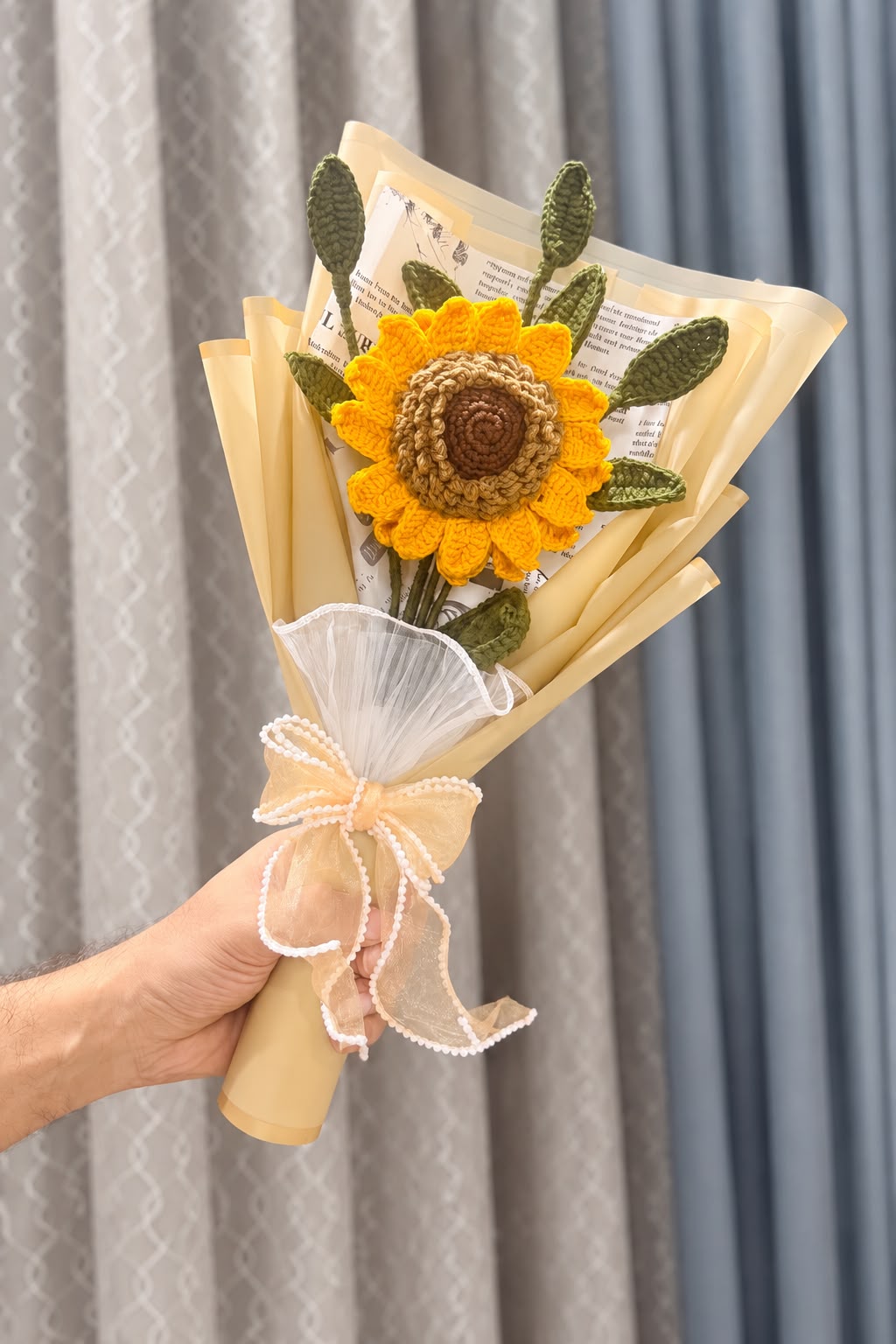 Crochet sunflower bouquet held in hand for size reference
