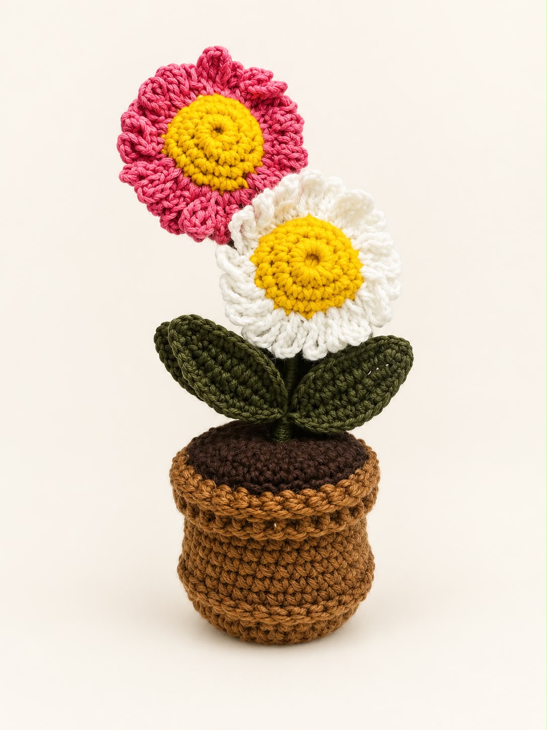 Blush Daisy Duo Pot – pink and white crochet daisies with yellow centres and green leaves in a brown crochet pot