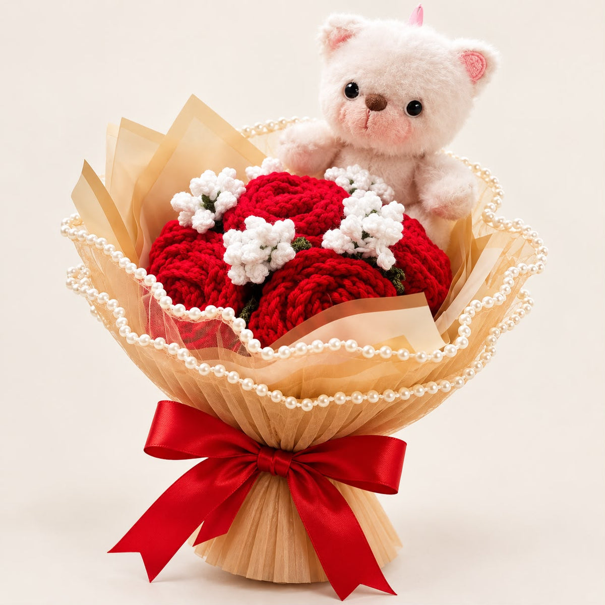 Crimson Cuddles bouquet with a plush teddy bear, crimson crochet roses, champagne wrapping, pearl detailing and red satin ribbon.
