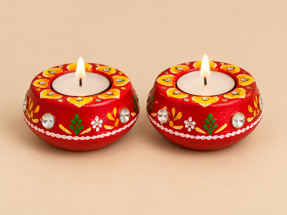 Set of two decorated wax-filled clay diyas