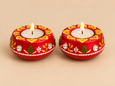 Set of two decorated wax-filled clay diyas