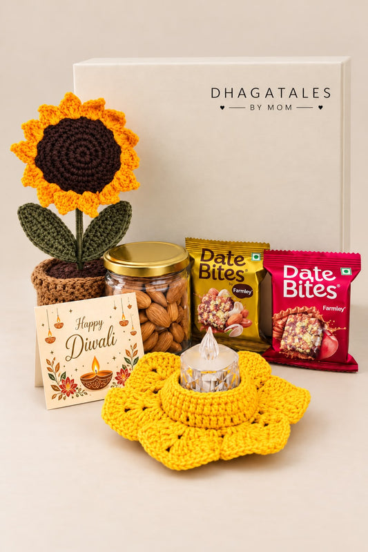 Golden Glow Diwali gift hamper with crochet sunflower pot, almond jar, two Farmley Date Bites packs, yellow crochet tealight holder, Diwali card and ivory gift box