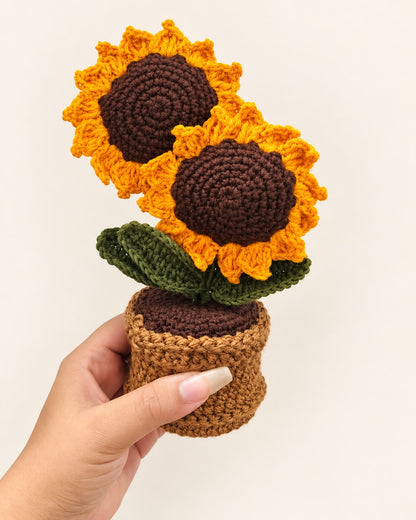 Golden Sunflower Duo Pot held in a hand, showing the two crochet sunflowers and pot