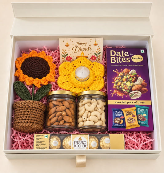 Overhead view of Shubh Aarambh Diwali hamper arranged in an ivory box with pink paper filling
